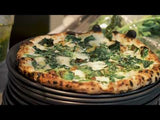 Video of Spinaci pizza being sliced with pesto and crema being added