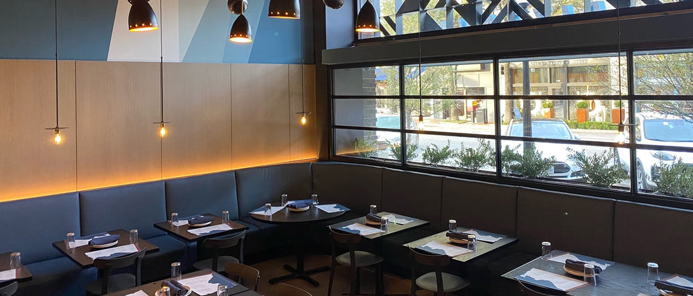 Interior of Pizzana Dallas with comfortable seating, warm lighting and large windows