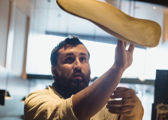 Chef and master pizzaiolo Daniele Uditi tossing pizza dough into the air