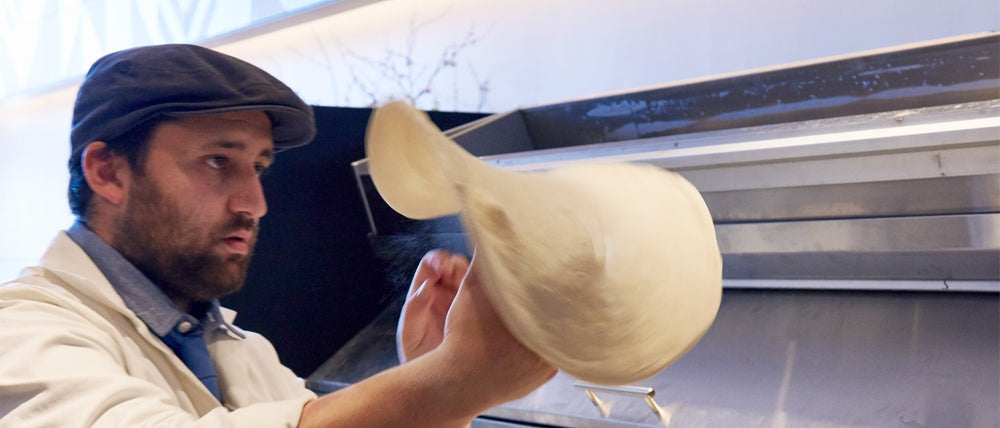 Chef and master pizzaiolo Daniele Uditi tossing pizza dough into the air
