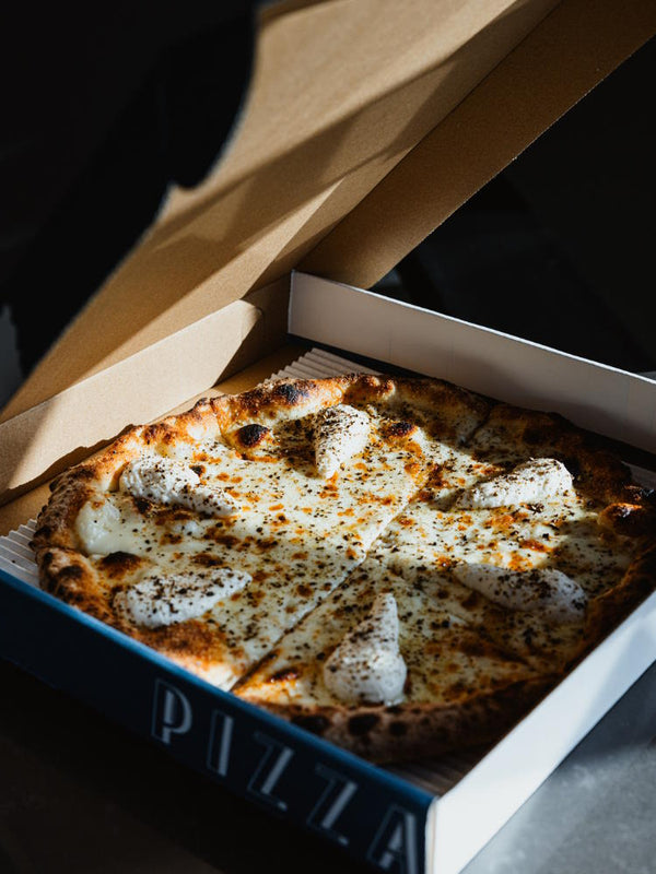 Cacio e Pepe pizza with cheese and pepper in pizza delivery box