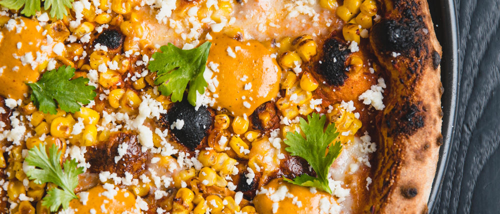 Elote di Strada pizza with wood fired bell pepper ranchero, queso oaxaca, charred corn, chipotle crema, cotija cheese and cilantro