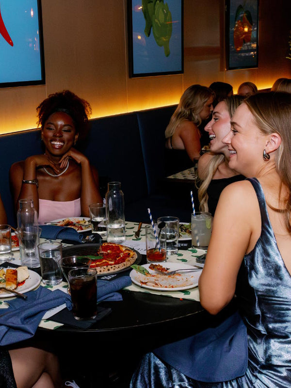 Women enjoying pizza at Pizzana