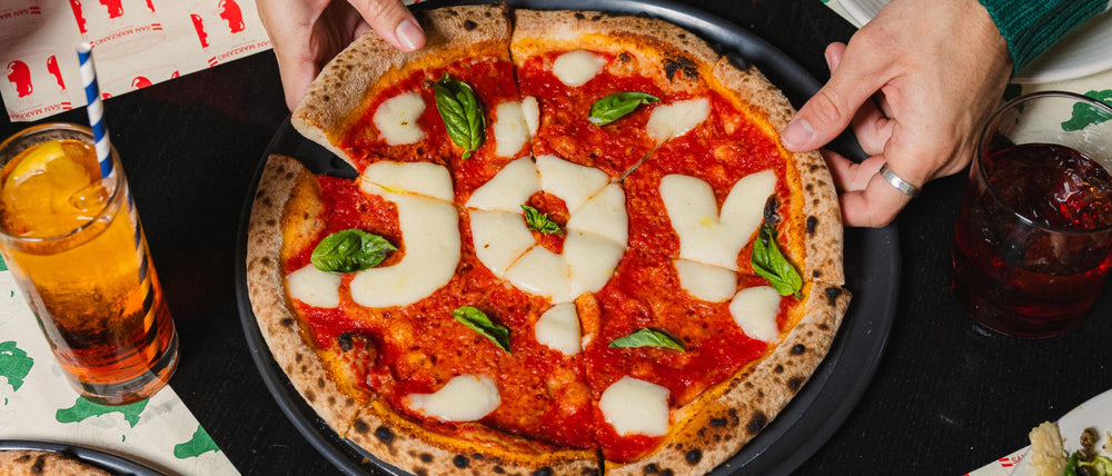 Merry Margherita pizza with JOY written in fior di latte cheese letters