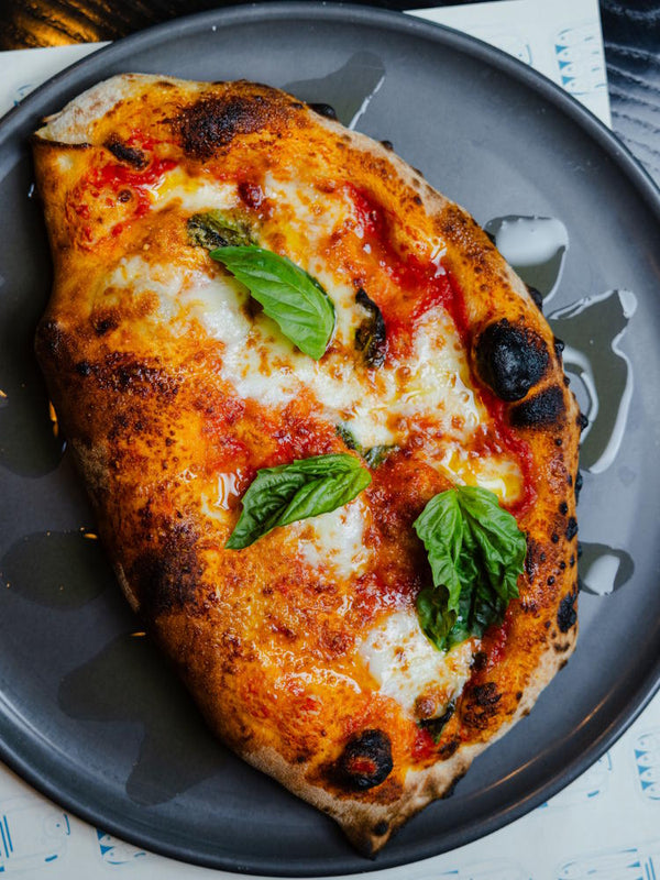 Calzone folded over pizza filled with ricotta, san marzano dop, fior di latte and black pepper