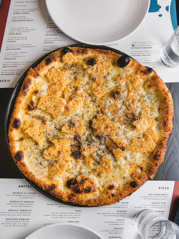 Quattro Formaggi four cheese pizza featuring fontina, fior di latte, gorgonzola, parmigiano crisp and truffle oil.