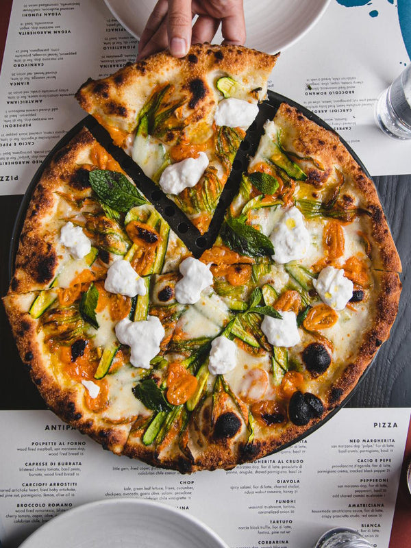 Sole d’Oro featuring fior di latte, sun gold tomato confit, squash blossom, baby zucchini, parmigiano, burrata and mint