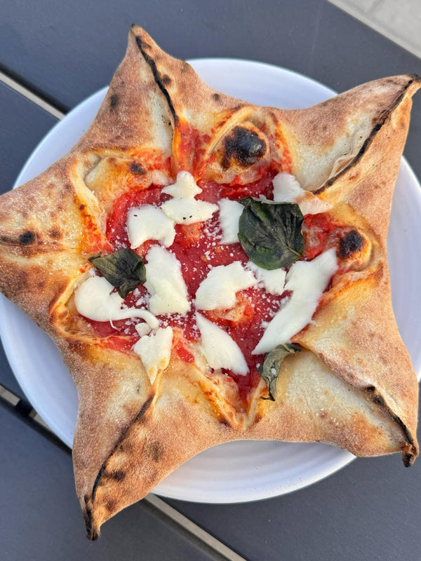 Stella pizza shaped in a star for the holidays with fior di latte, san marzano top and basil