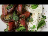 Video of knife slicing into tomato and fork lifting up perfect bite of Caprese di Bufala