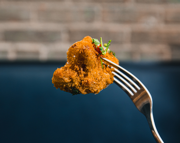 Closeup of fork holding up golden crispy panko cauliflower 