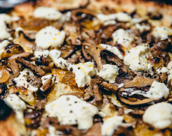 Closeup of Vegan Funghi pizza with seasonal mushroom and vegan cauliflower besciamella